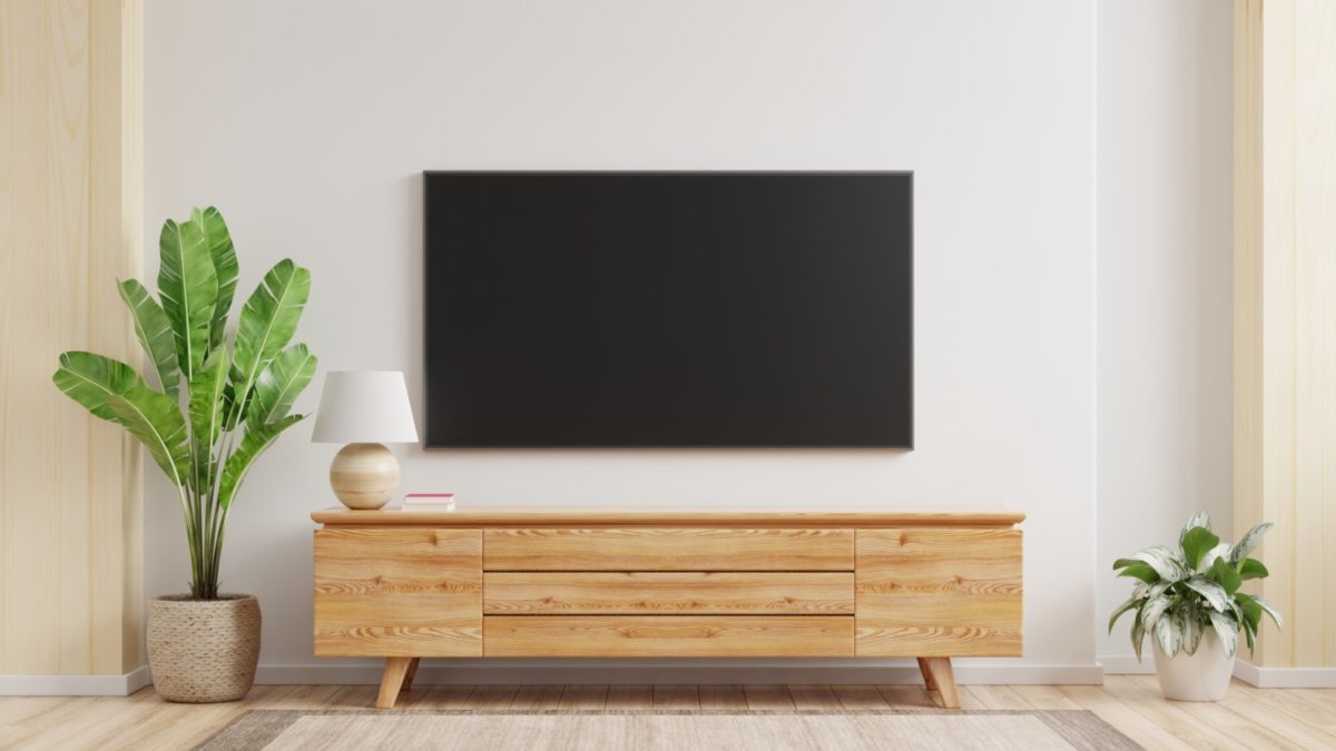 A TV is mounted on a wall with no wires visible.