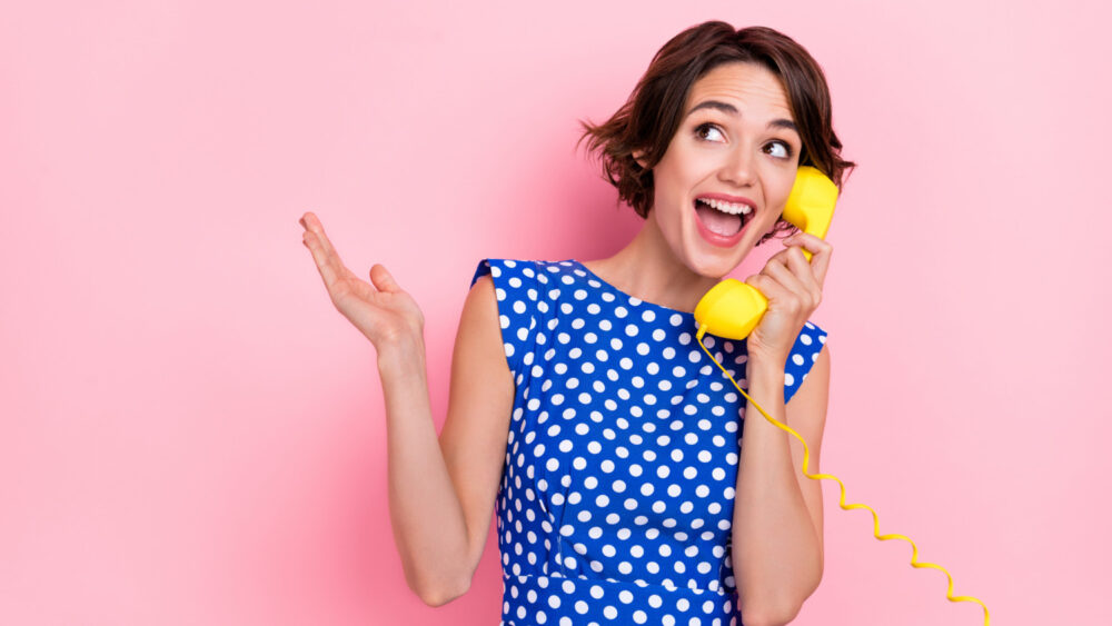 Woman talks on landline telephone